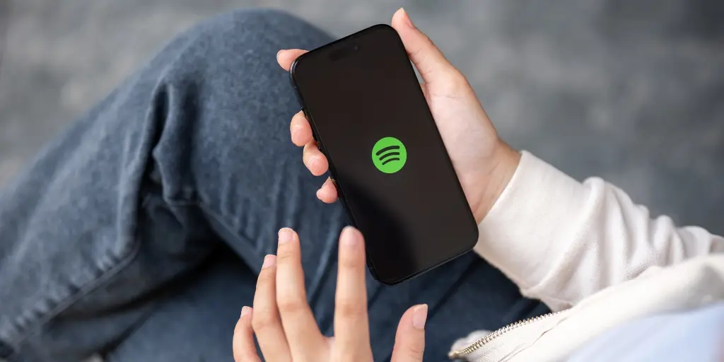 person on their phone with Spotify up