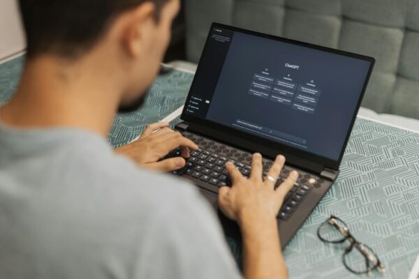 man working on computer with OpenAI pulled up.
