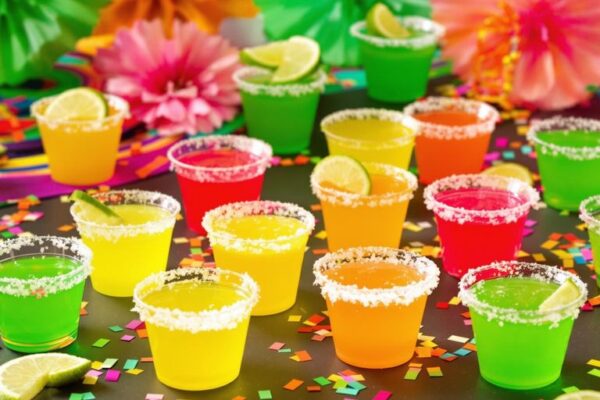 Colorful margarita jello shots with lime wedges and salt rims