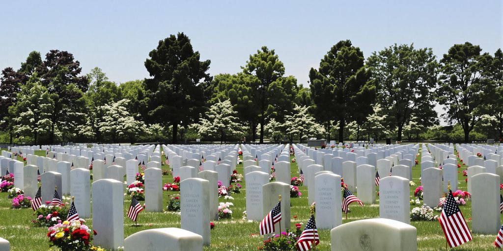 White headstones with flags at a peaceful military cemetery