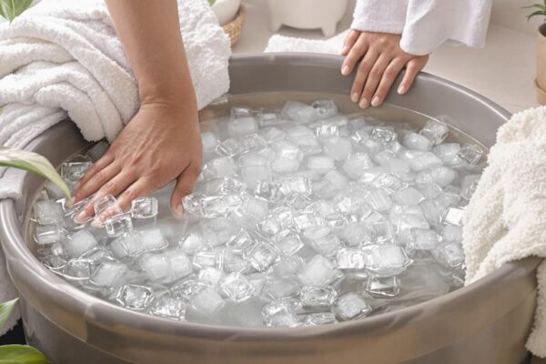 Person entering icy water in a home bathroom