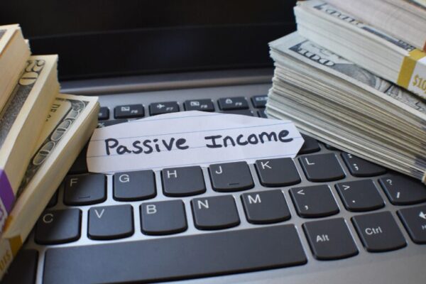 Passive Income Streams You Can Start with Less Than $500 Stacks of money beside a keyboard labeled "Passive Income."