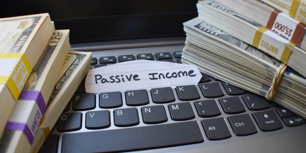 Stacks of money beside a keyboard labeled "Passive Income."
