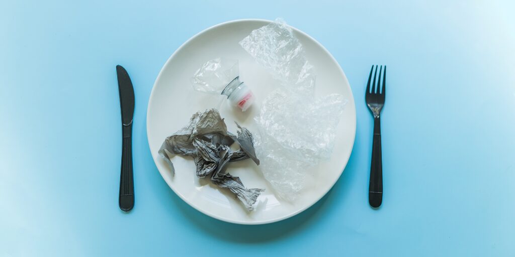 plastic on a plate with fork and knife on side of plate