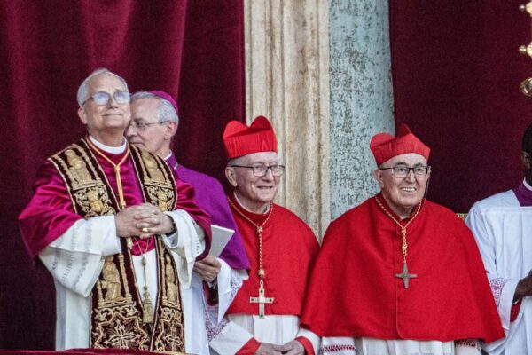 Newly elected Pope Leo XIV stands on the Vatican balcony alongside cardinals and clergy following the announcement of his papacy.