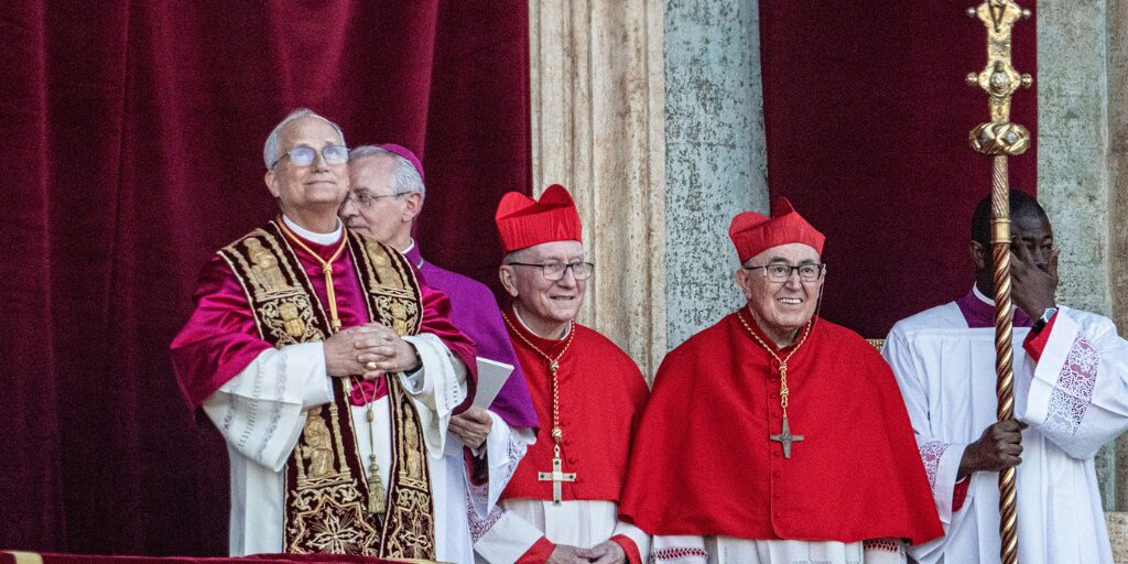 Newly elected Pope Leo XIV stands on the Vatican balcony alongside cardinals and clergy following the announcement of his papacy.
