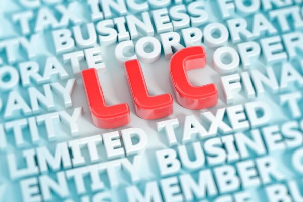 Red 3D letters spelling “LLC” surrounded by business-related terms like “entity,” “corporation,” and “taxed” in a blue background