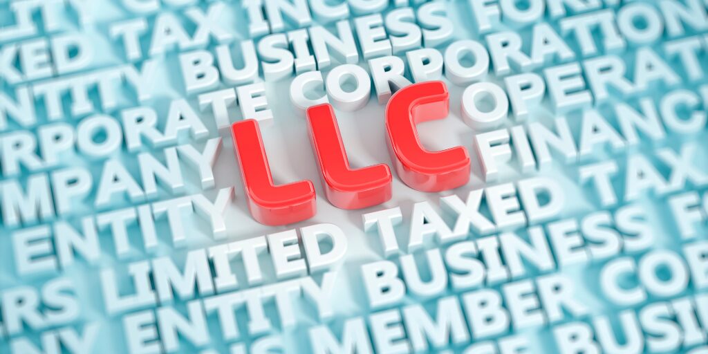Red 3D letters spelling “LLC” surrounded by business-related terms like “entity,” “corporation,” and “taxed” in a blue background