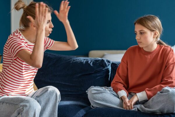 Toxic Parenting Phrases to Avoid Mom yelling at daughter on the couch.