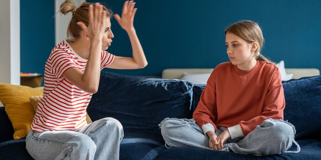 Mom yelling at daughter on the couch.