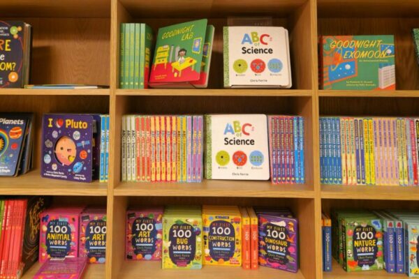 Children's books on a shelf in a library.