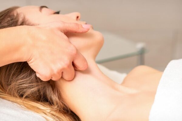 Therapist performing lymphatic drainage massage in tranquil spa.
